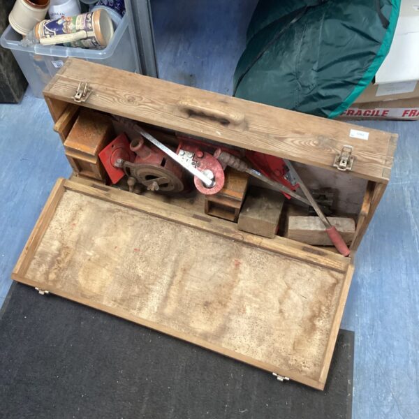 Vintage wooden carpenters toolbox filled with antique hand tools.