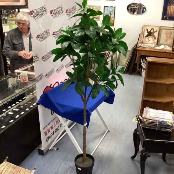 Artificial indoor tree displayed in a room setting.