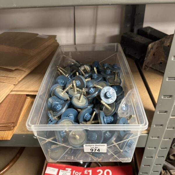 Tray of galvanised metal roofing bolts for construction projects.