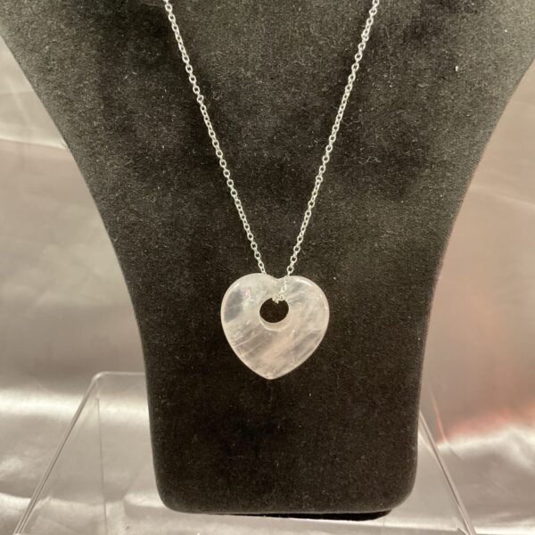 Delicate rose quartz necklace with silver pendant on a chain.