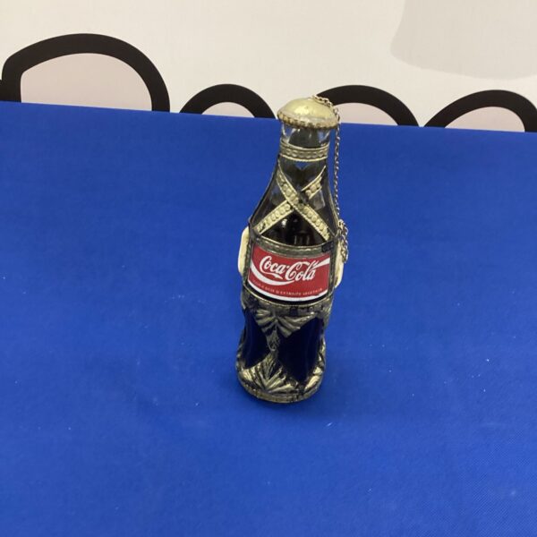 Vintage decorated Coca-Cola glass bottle, collectible soda pop item.