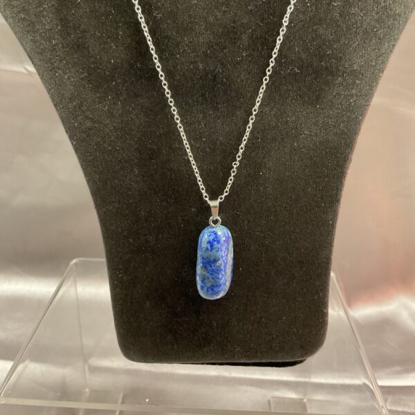 Polished lapis lazuli pendant on a silver chain necklace.