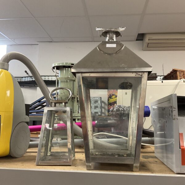 Two large metal candle lanterns with clear glass panels.