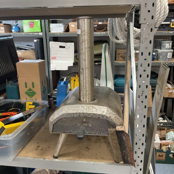 Side view of a stainless steel Ooni pizza oven.