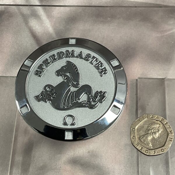 Detailed Omega Speedmaster paperweight, a collectible desk ornament.