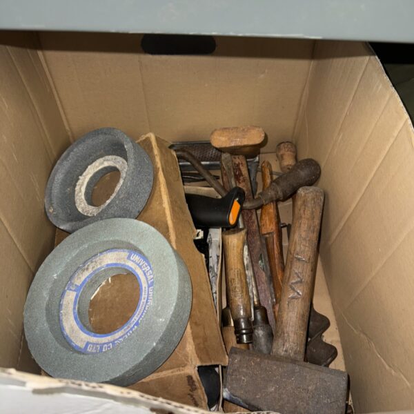 Assorted vintage hand tools in a workshop lot, including hammers and chisels.