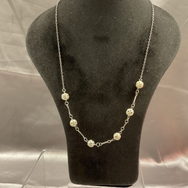 Polished 925 silver ball necklace on a display.