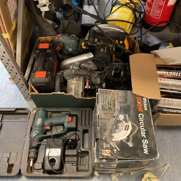 Mixed lot of power tools in a plastic tray, including drills and saws.