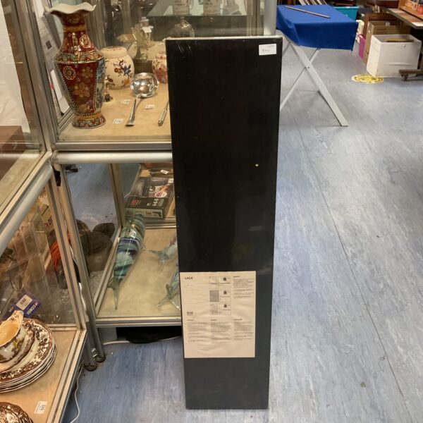 Black Ikea Lack shelf unit against a wall.
