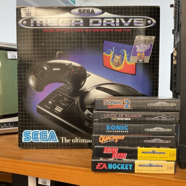 Sega Mega Drive console with boxed games and controller.