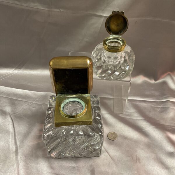 Pair of antique cut glass inkwells with brass lids.