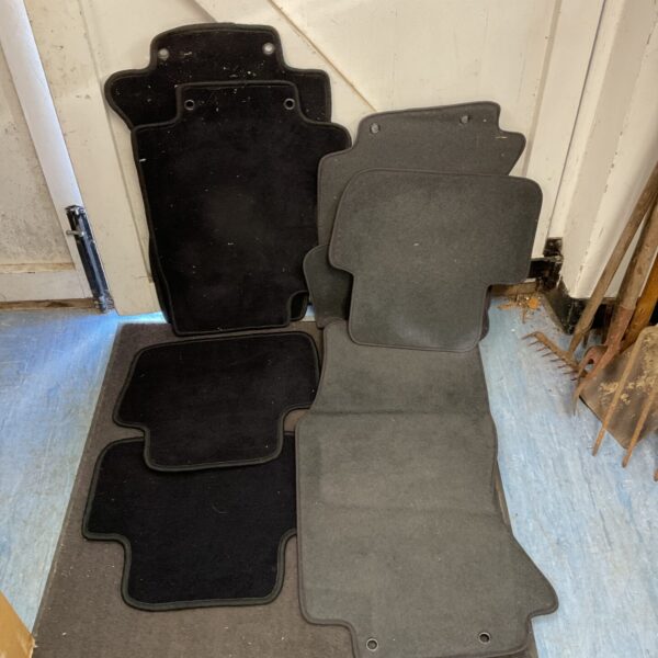 Two sets of dark Jaguar car mats for vehicle interiors.