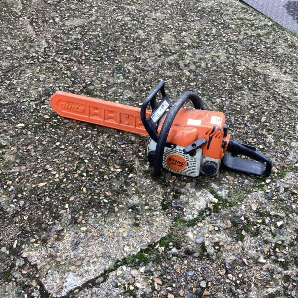 Side view of a used Stihl petrol chainsaw for garden work.