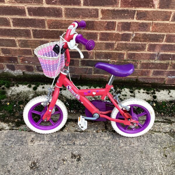 Red vintage style childrens bike with white basket.