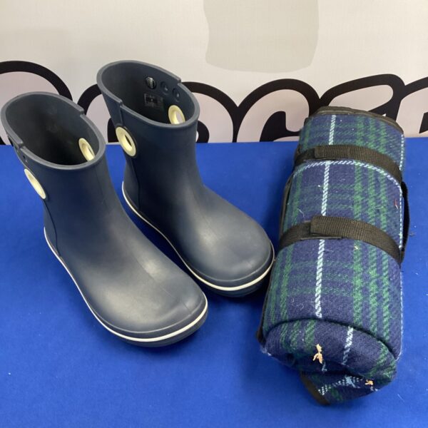 Size 7 Crocs with tartan picnic blanket for outdoor use.
