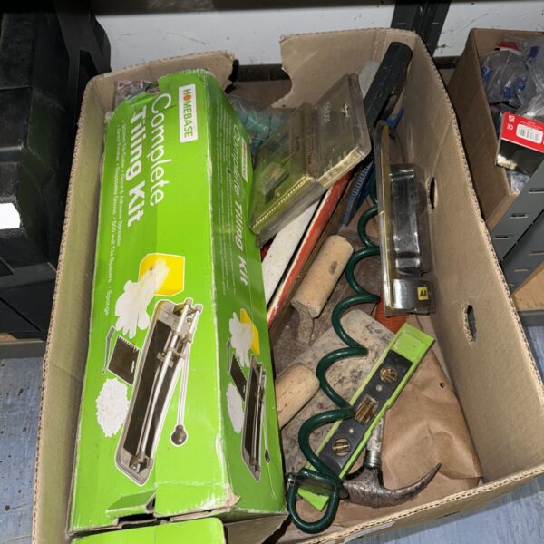 Tiling kit contents within a cardboard box from shed clearance.