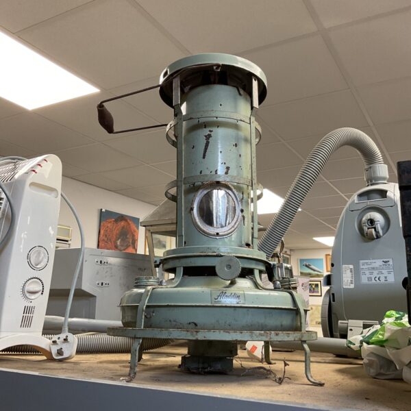 Vintage green Aladdin paraffin heater for greenhouse or workshop use.