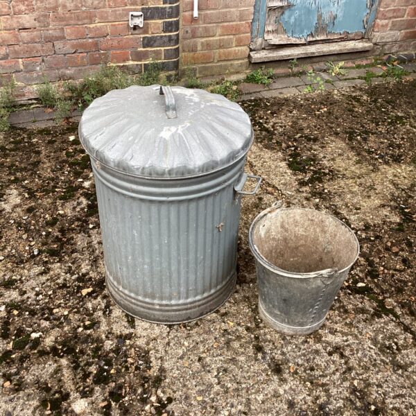 Vintage galvanised waste bin and bucket in a garden setting.