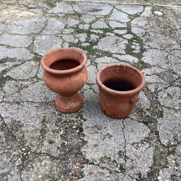 Pair of weathered terracotta garden planters for outdoor use.