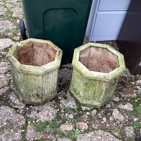 Pair of weathered stone effect garden planters for outdoor use.
