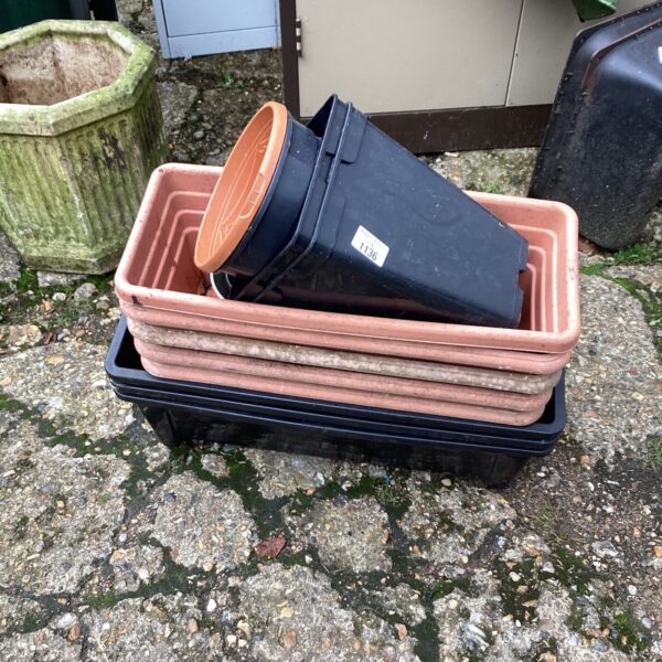 Assorted plastic garden pots stacked for storage, ideal for gardening.