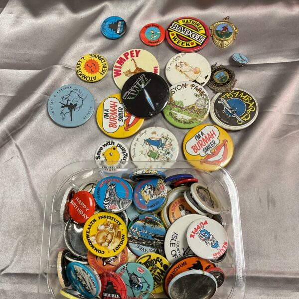 Lot of vintage button badges, collectible pinback buttons, retro designs.