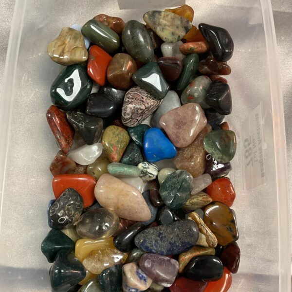 Polished crystal tray with assorted tumbled stones and gemstones.