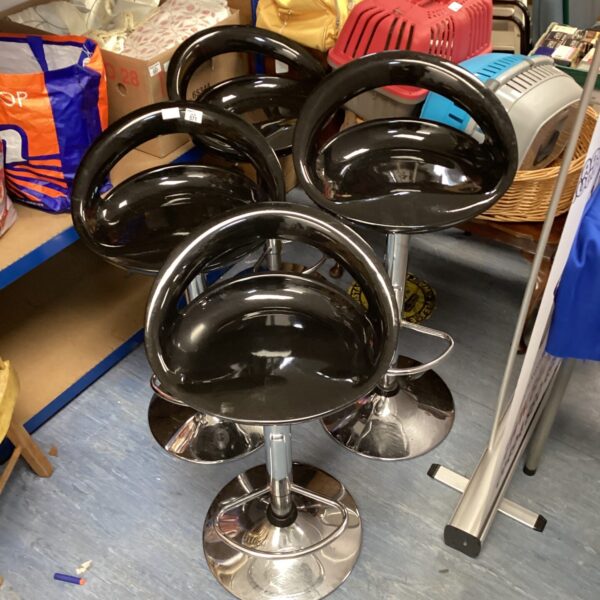 Set of four black and chrome swivel bar stools for kitchen or bar.