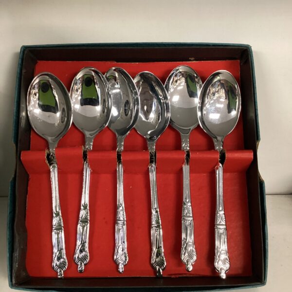 Antique silver apostle spoons displayed on red velvet.