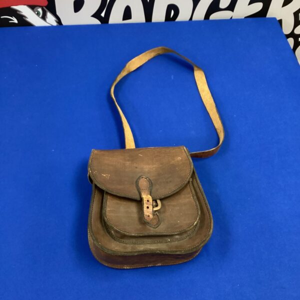 Vintage leather shooting bag with shoulder strap, antique hunting accessory.