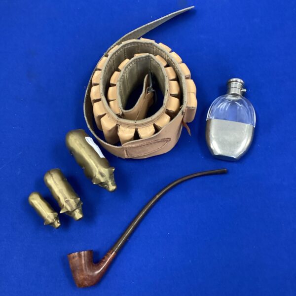 Vintage cartridge belt with hip flask, pipe and brass pigs.