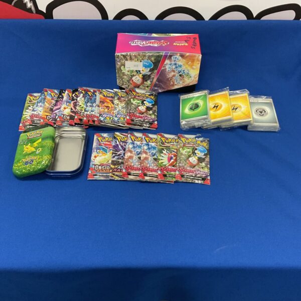 Opened Pokémon booster packs and tin with collectible cards.