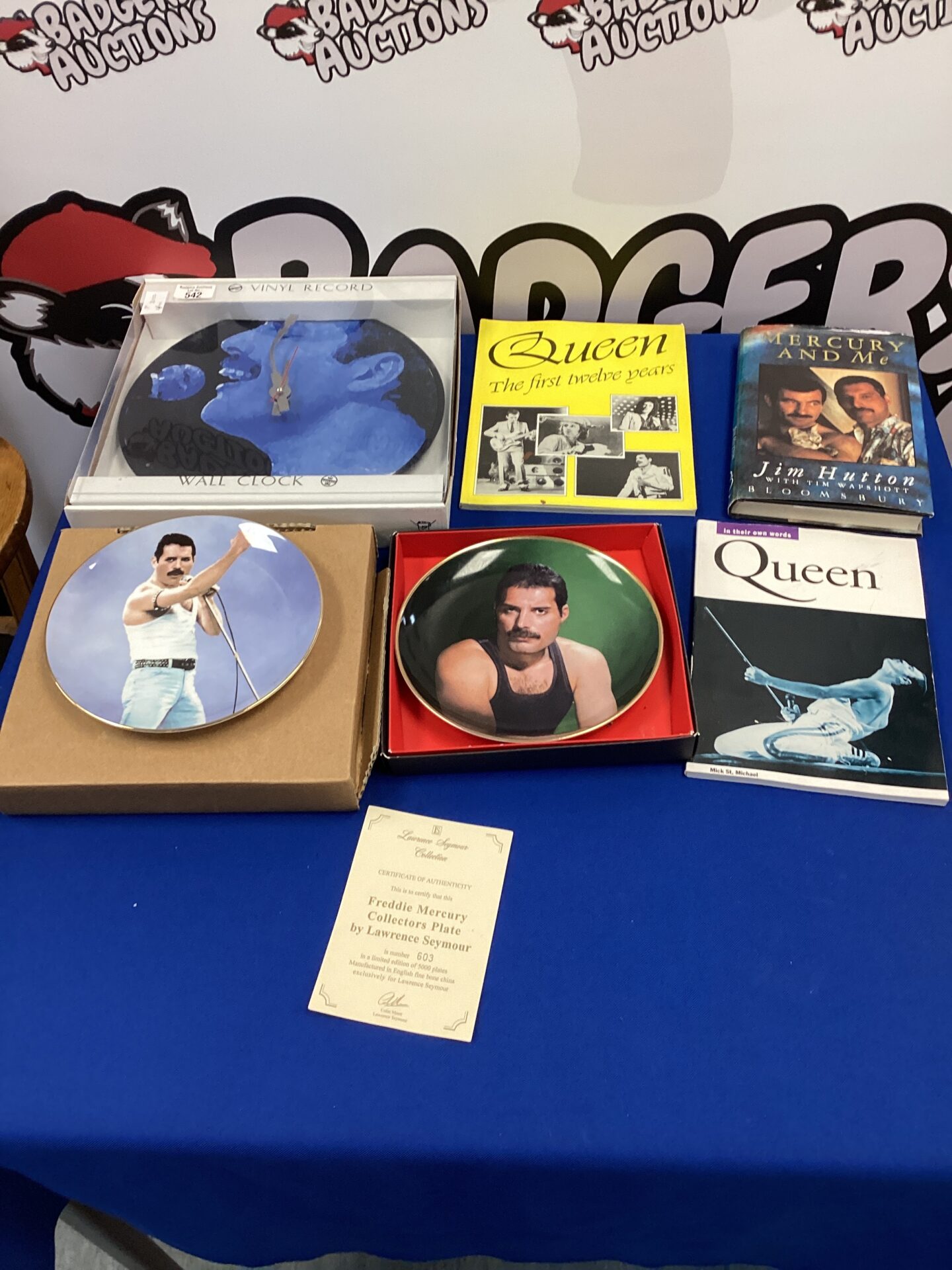 542 Queen memorabilia with decorative collectors plates, wall clock & books