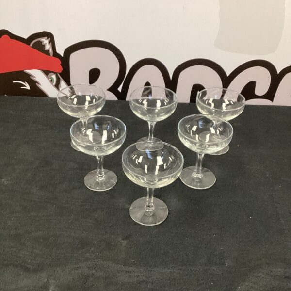 Set of six vintage champagne glasses on a dark background.