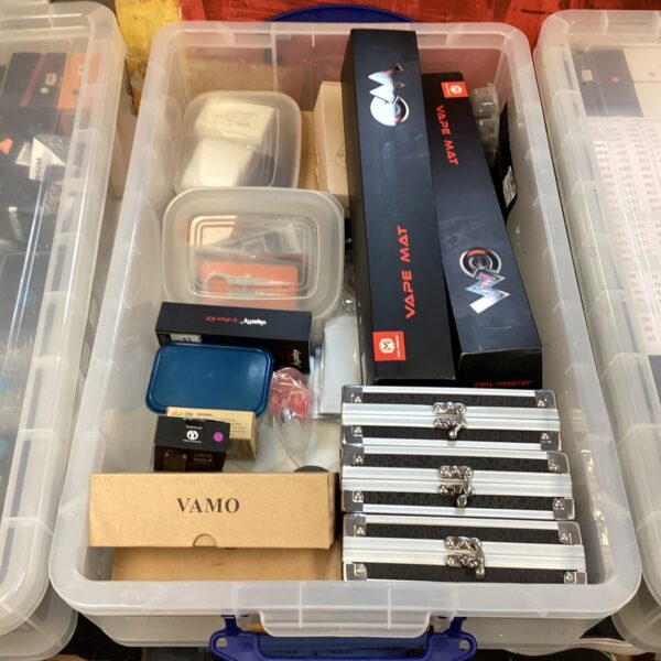 Collection of vape tanks, mods, and a vape mat for vaping.