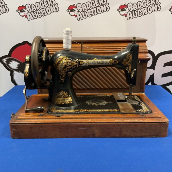 Ornate antique Singer sewing machine with decorative details.
