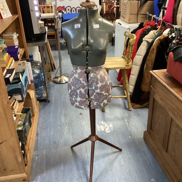 Vintage dressmaker mannequin on tripod base, classic sewing form.