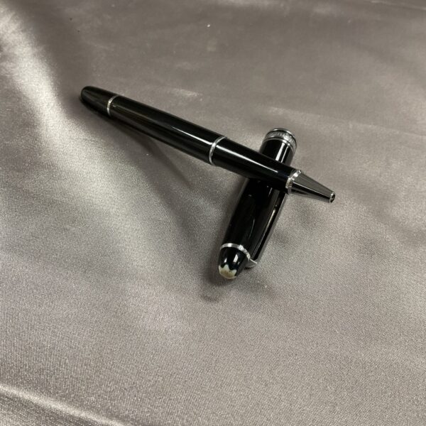 Black Montblanc style ballpoint pen on grey fabric.