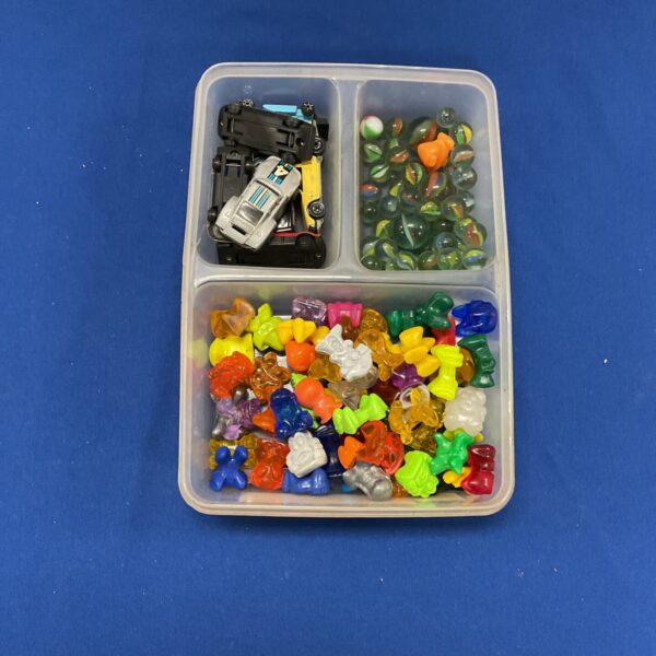 Colourful mixed toy lot with Crazy Bones, marbles and small cars.