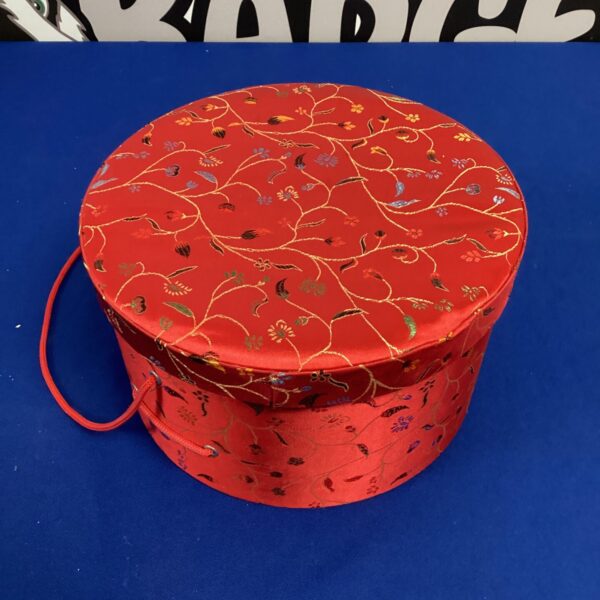 Red silk Japanese hat box with gold floral pattern.