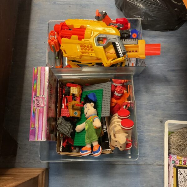 Overview of a mixed toy lot including Nerf gun and Lego bricks.