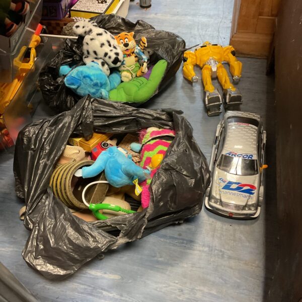 Overview of a mixed toy lot including teddy bears and a transformer.