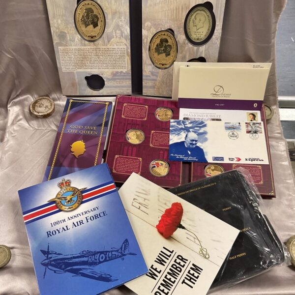 Commemorative coin collection and first day stamp covers featuring Queen Elizabeth II.