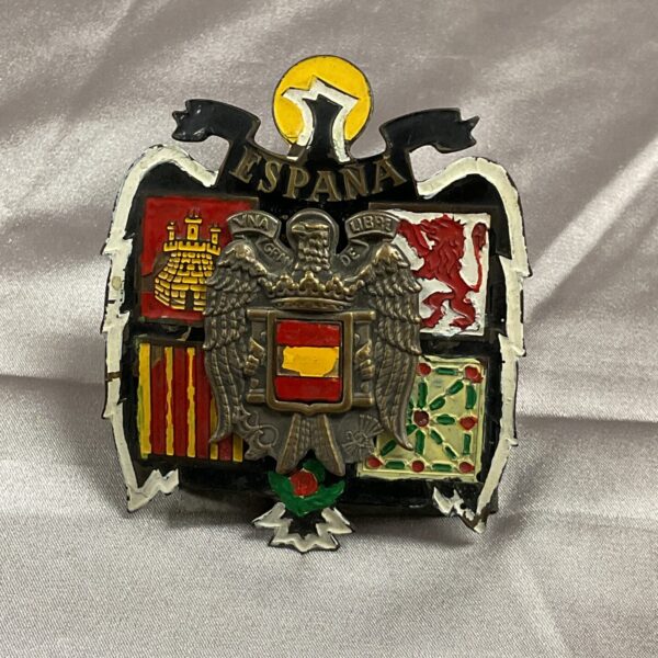 Vintage Espania car badge with detailed crest design.