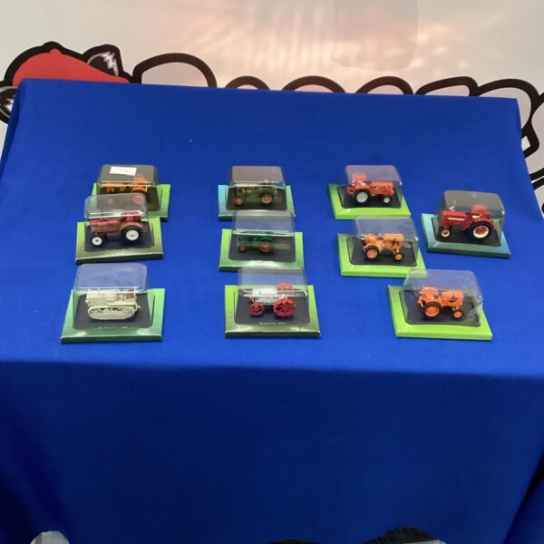 Diecast model tractors in display boxes, collectible farm toys.