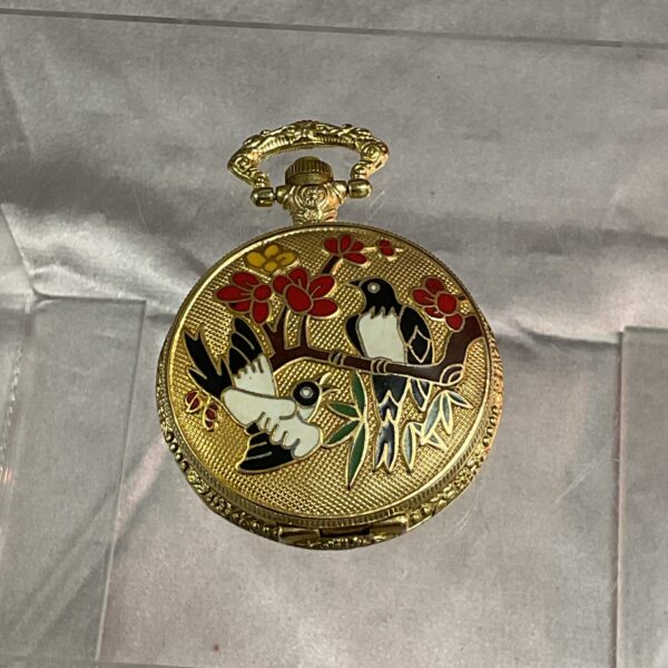 Vintage enamel pocket watch with bird design.