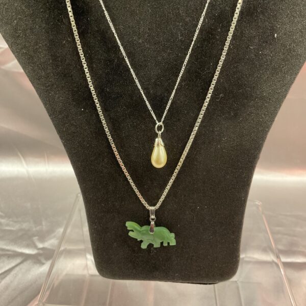 Silver pendant necklace set featuring an elephant and pearl.