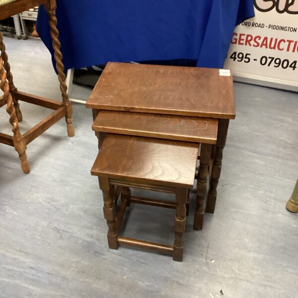 Vintage dark oak nest of tables in a living room setting.