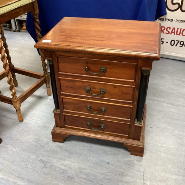 Front view of a vintage four-drawer wooden chest of drawers.