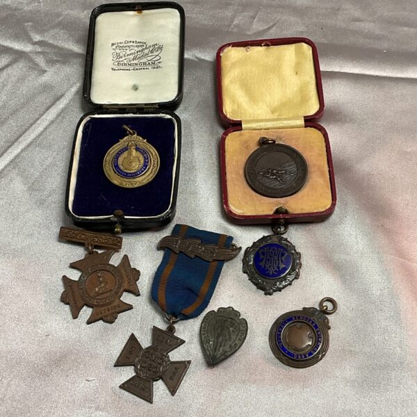 Vintage medal collection including swimming and nursing awards.
